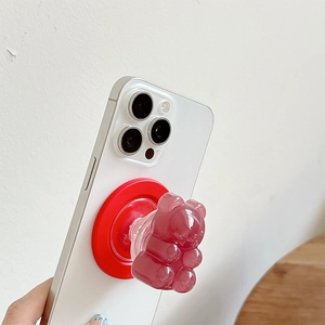 Detail of pink resin gummy bear magnetic phone holder with red MagSafe ring base