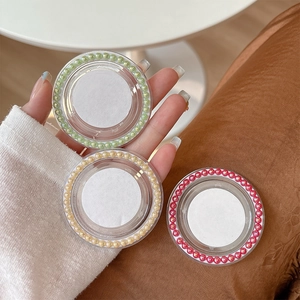 Set of three colorful pearl phone grip sockets with clear acrylic borders on a neutral base