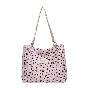 Pink quilted tote bag with black bow patterns and elegant fashion leather label