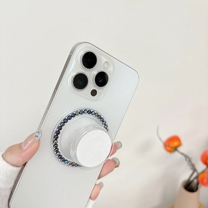 Detail showing magnetic phone grip with colorful iridescent pearls on white smartphone