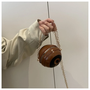 Close-up of caramel leather 8-ball spherical mini crossbody bag with gold chain strap