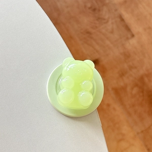 Close-up of a light green translucent bear-shaped magnetic phone grip with jelly texture