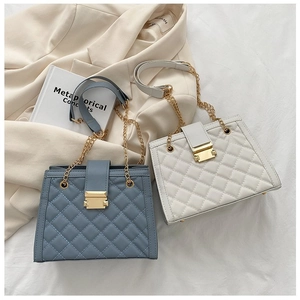 Detail of quilted leather texture with golden rectangular buckle on stylish chain bags
