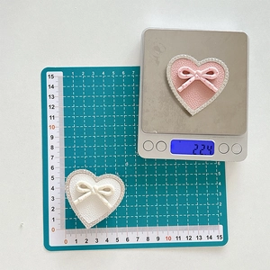 Detail view of heart-shaped rhinestone phone grip showing weight of 22.4g and 5.5cm size