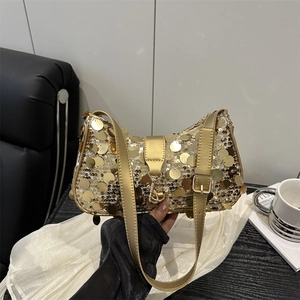 Fashionable gold sequin underarm bag with large round metallic discs for a party look