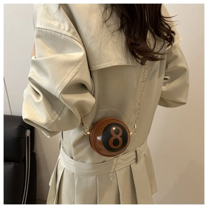 Detailed view of billiard ball shaped crossbody bag with number 8 and gold chain strap