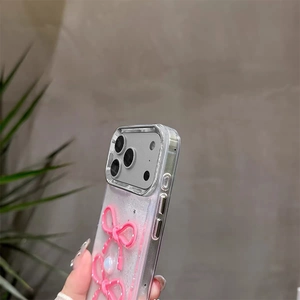 Details von rosa 3D-Schleifen und Perlen auf glitzernder iPhone-Hülle mit Kamera-Ausschnitt