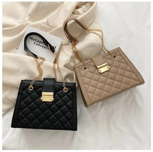 Close-up of quilted chain handbags in black and khaki with gold hardware detail