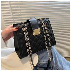 Detail of a black quilted chain shoulder bag featuring a golden metal buckle and hardware