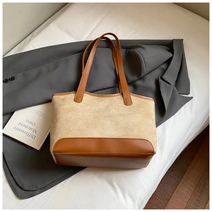 Detail of a vintage-style tote bag with contrast brown PU leather and beige fabric textures