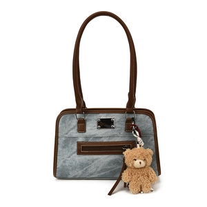 Fashionable marble pattern tote bag with brown trim and bear charm on white background