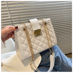 Detail of white quilted crossbody bag with golden square metal clasp and chain strap