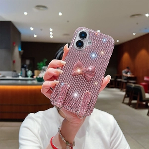 Detail of pink rhinestone phone case featuring a sparkling bow and dual metal lanyard rings