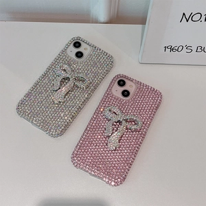 Close-up of sparkling full diamond bow phone cases in silver and pink colors
