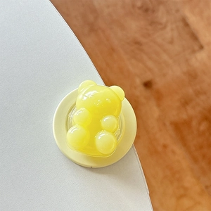Detail of yellow translucent gummy bear phone grip stand with a glossy resin finish