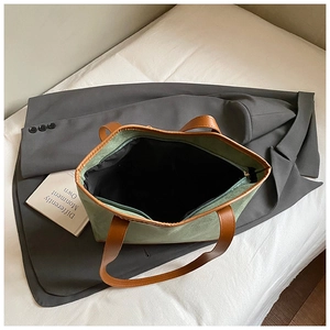 Top view of spacious interior with zipper pocket in a green suede tote bag
