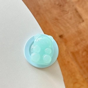 Detail view of mint green bear pop socket accessory with a soft jelly texture for phone grip