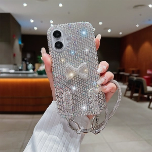 Close-up of sparkling rhinestone bow phone case with a matching glittery hand strap