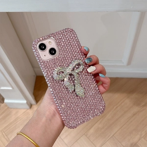 Detailed close-up of a pink rhinestone iPhone case with a luxury crystal bow ornament
