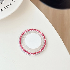 Detail of pink pearl bead circular phone socket grip with white center on desktop