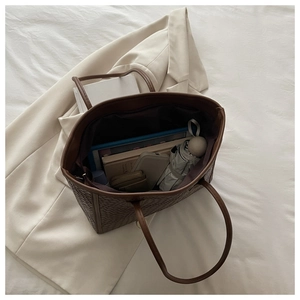 Vista dall'alto di una borsa tote intrecciata marrone con ampio spazio interno per oggetti vari