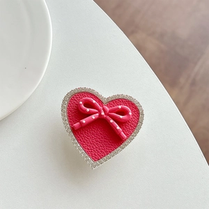 Detail of red leather heart phone grip with pink polka dot bow and rhinestone edge