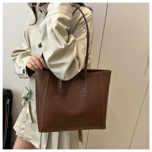 Dettaglio della grande borsa tote intrecciata marrone scuro con trama testurizzata fine