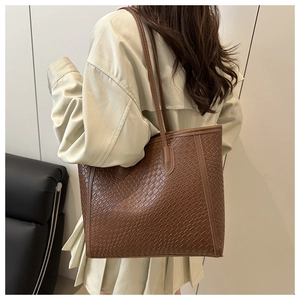 Dettaglio della borsa tote marrone con trama a incrocio per un look elegante e raffinato