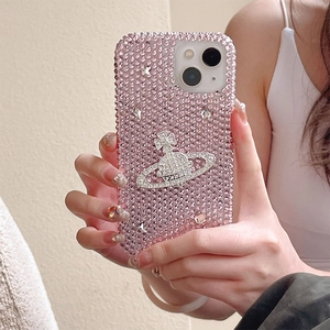 Detail of luxury pink rhinestone phone case featuring silver Saturn planet emblem