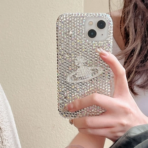 Detail shot of luxury iridescent rhinestone iPhone case with metallic planet emblem