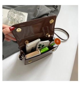 Détail du sac en cuir verni marron foncé avec boucle magnétique et intérieur spacieux