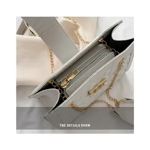 White quilted crossbody bag with gold chain strap and organized multi-layer interior