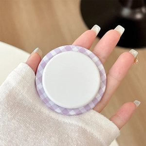 Close-up of a purple plaid Magsafe phone socket holder being held by hand for stability