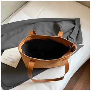 Detailed top view of large brown tote bag with zipper closure and spacious black lining