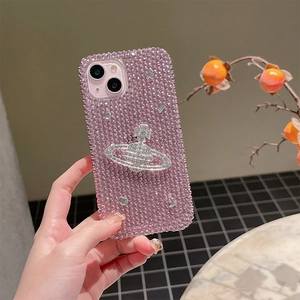 Detail of pink rhinestone iPhone case featuring a silver Saturn cross emblem decoration