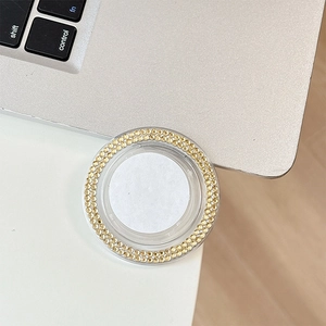 Close-up of a round rhinestone phone grip holder with sparkling champagne crystals
