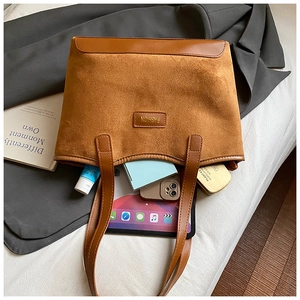 Detailed top view of a brown suede tote bag holding a tablet and daily accessories