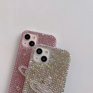 Detail of luxury rhinestone iPhone cases featuring sparkling Saturn orb metal embellishments