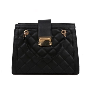 Black quilted shoulder bag with gold hardware and studs on a white background