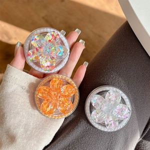Sparkly floral magnetic phone socket with colorful sequins and pearl trim held in hand
