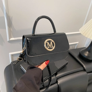 Sac à main chic en cuir verni noir avec boucle M dorée et bandoulière réglable