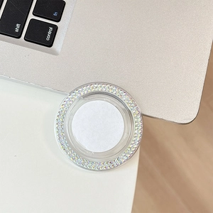 Macro detail of round phone socket with iridescent AB rhinestones on laptop surface
