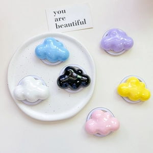 Cloud-shaped glossy phone grips in six pastel colors on a stylish ceramic tray