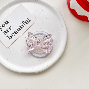 Detail of pink glittery bow magnetic phone socket on a white artistic ceramic plate