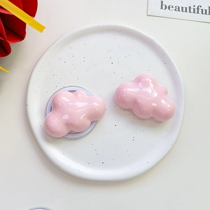 Detail of glossy pink cloud phone grip on decorative marble plate with minimal ornaments