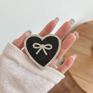 Macro shot of glittery heart phone grip with bowknot design and sparkling rhinestones