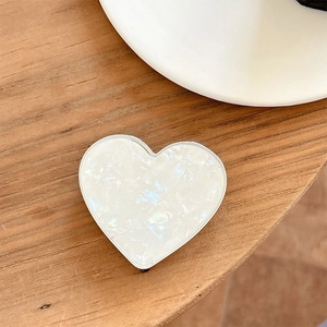 Detail of heart-shaped phone grip with white marble texture and silver metallic edge