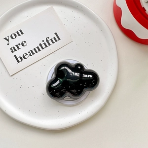 Black glossy cloud-shaped phone socket on a white ceramic plate with a minimal aesthetic