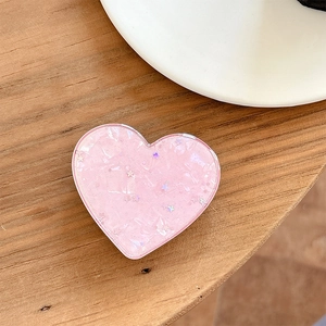 Close-up of pink heart-shaped phone grip with glitter star sequins and ice textures