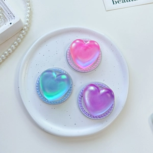 Detailed view of iridescent heart-shaped phone grips with elegant pearl-beaded edges